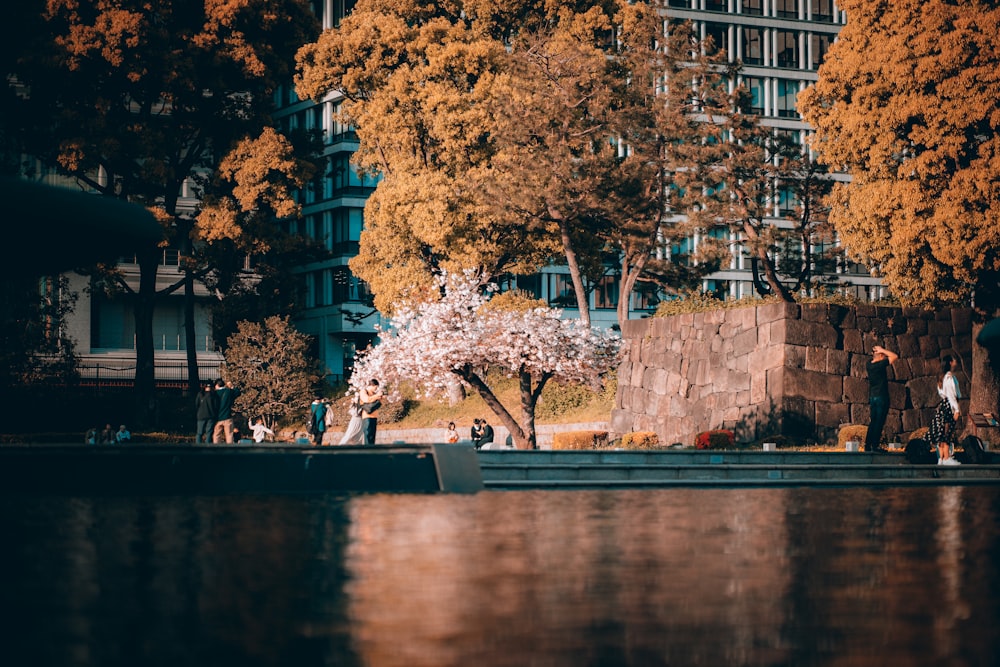 a boat floating down a river next to a tall building