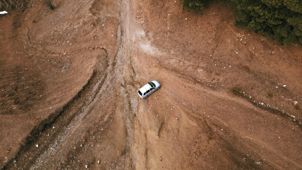 an aerial view of a truck driving on a dirt road