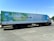 A large white truck with a trailer is parked on a road. The trailer features vibrant advertisements for a brand called Almarai, with the text 'Quality you can trust' written in both English and Arabic. The left side of the trailer displays illustrations of various food items, such as milk cartons, cheese, and limes.