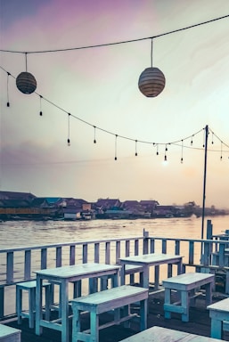 A peaceful waterfront venue at sunset with a wooden deck and gentle waves.