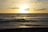 A serene ocean view from a private veranda at sunset, with soft golden light reflecting on the water.