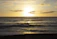 A serene ocean view from a private veranda at sunset, with soft golden light reflecting on the water.