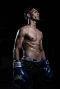 a man with no shirt wearing boxing gloves