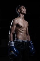 a man with no shirt wearing boxing gloves