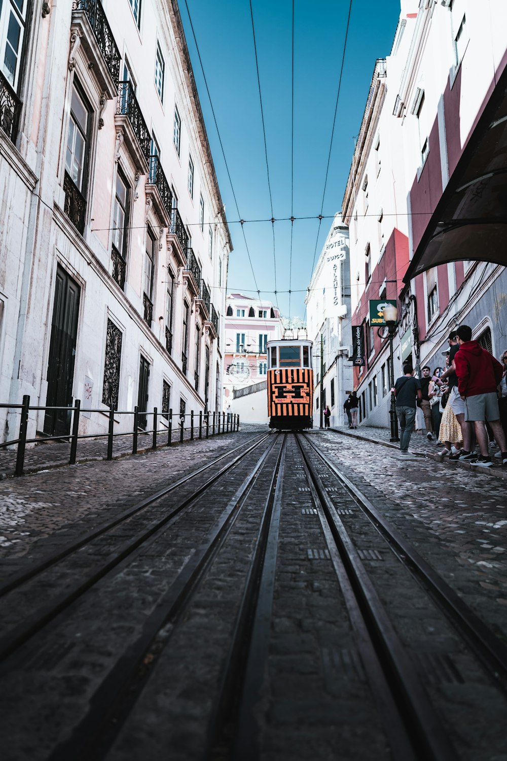 a trolley car traveling down a street next to tall buildings