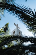 Statue of Shakira in Barranquilla surrounded by lush greenery and blue skies