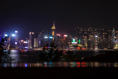A breathtaking nighttime skyline of Zurich with illuminated skyscrapers reflecting on the lake.