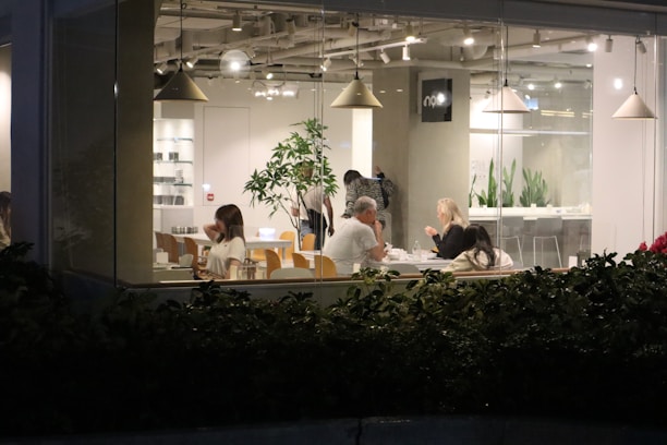 A small group of friends chatting happily inside the modern, intimate cafe space.