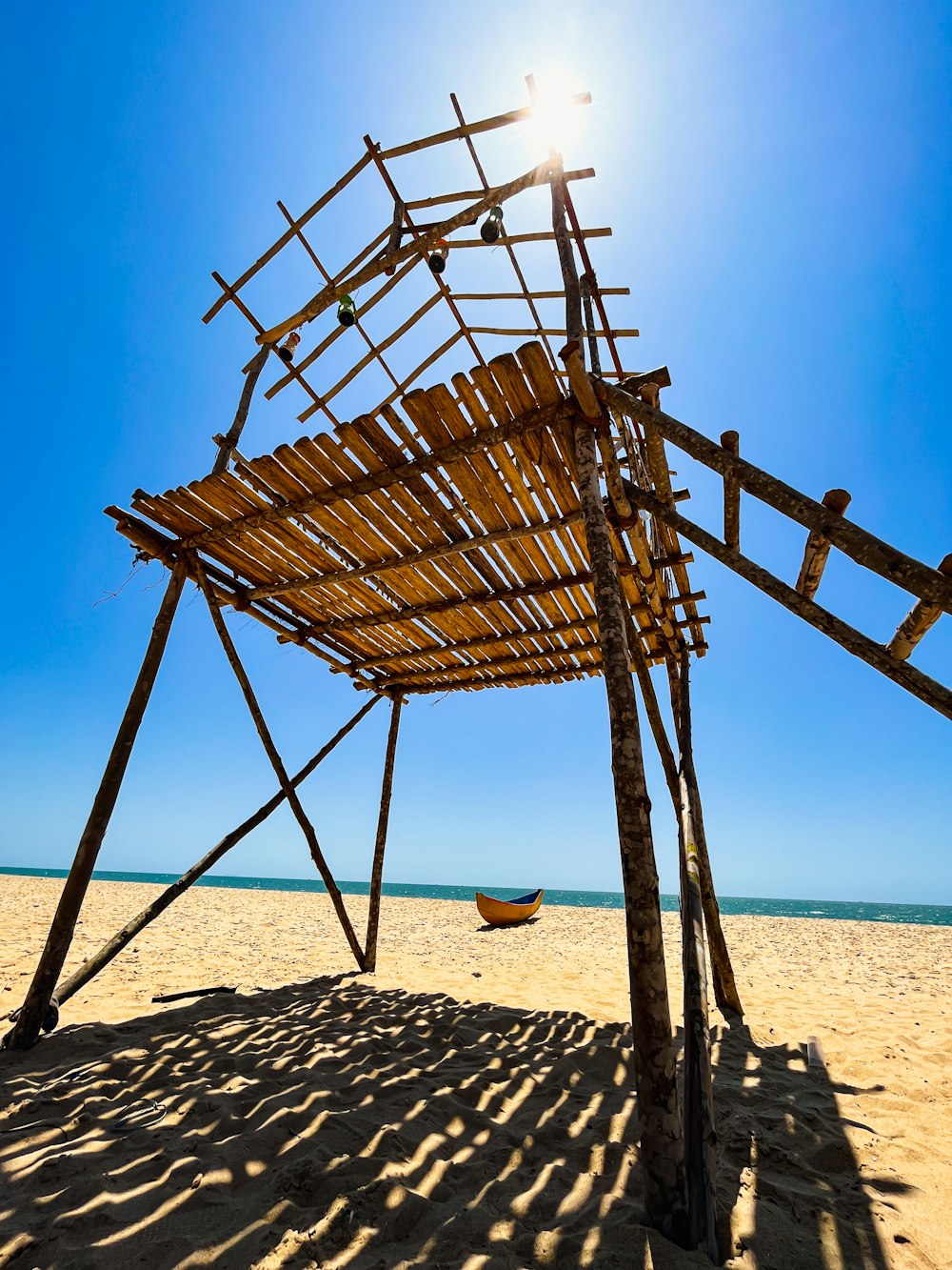 a wooden structure sitting on top of a sandy beach