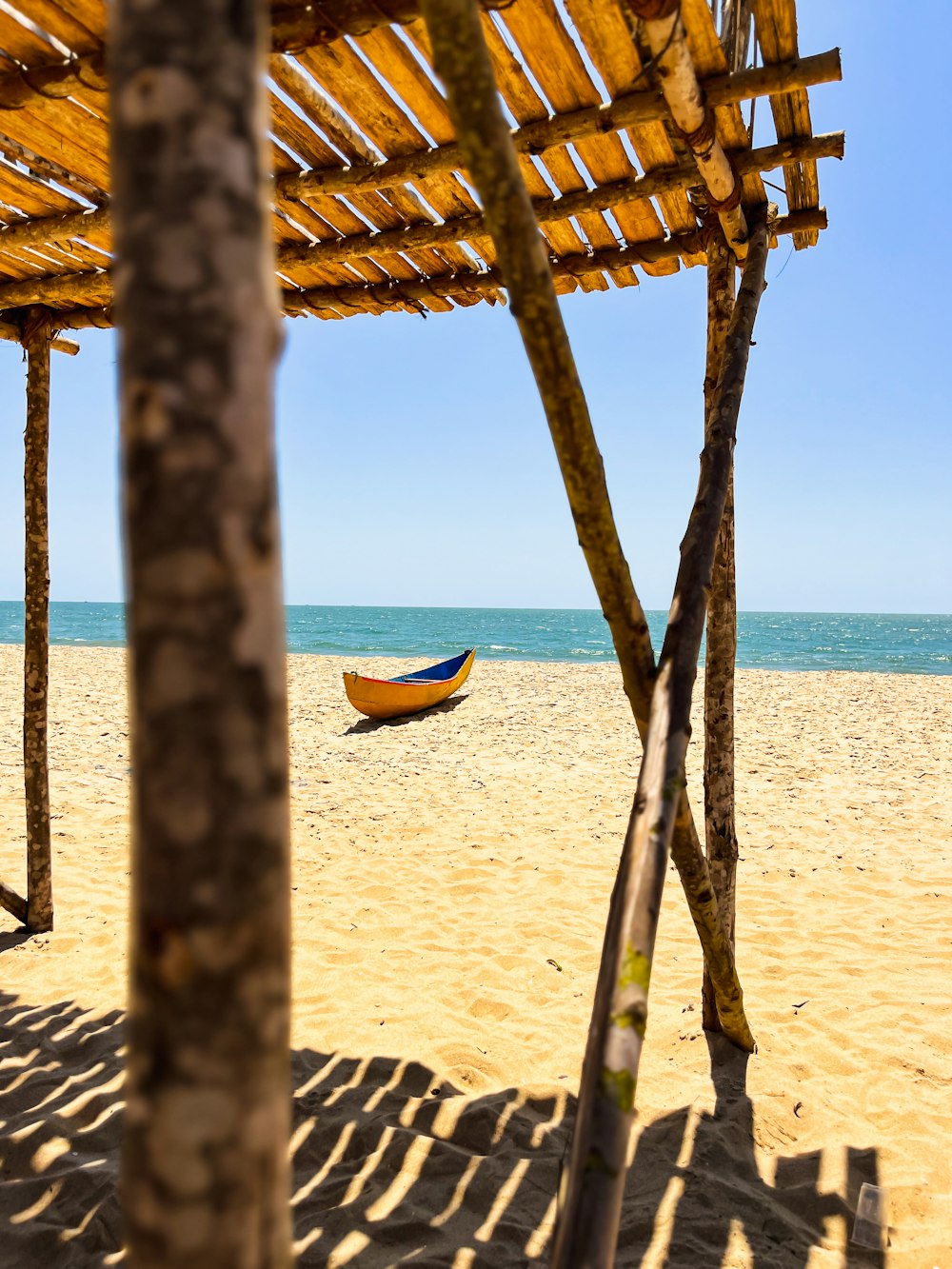 um barco amarelo sentado no topo de uma praia de areia