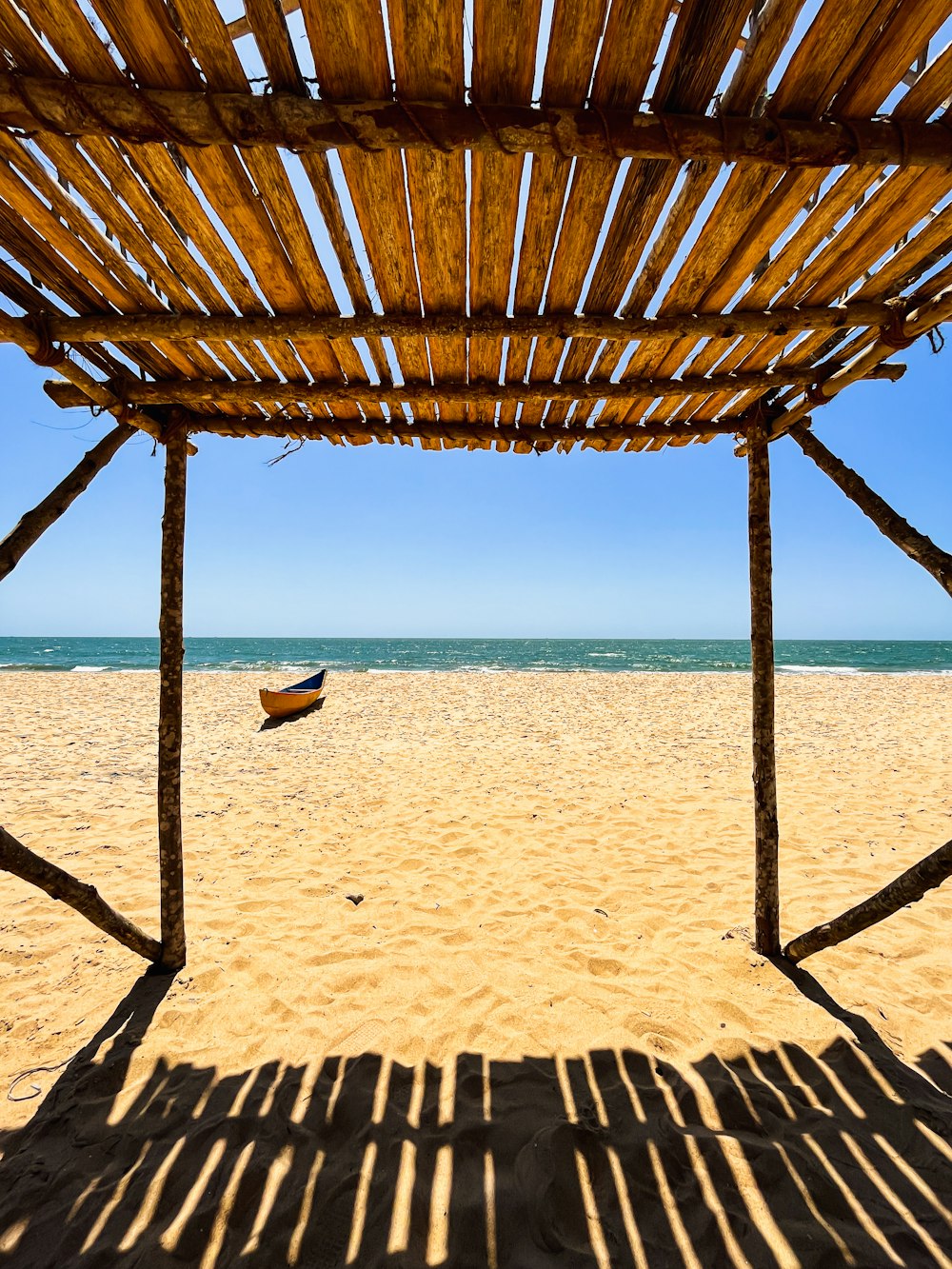 a wooden structure sitting on top of a sandy beach