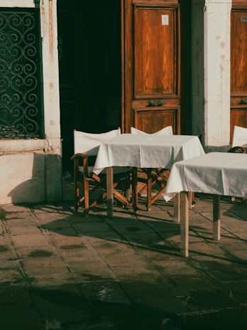 An outdoor café scene featuring a model in a chic outfit with natural lighting.