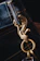 A close-up of a colorful keychain hanging from a rustic wooden hook.