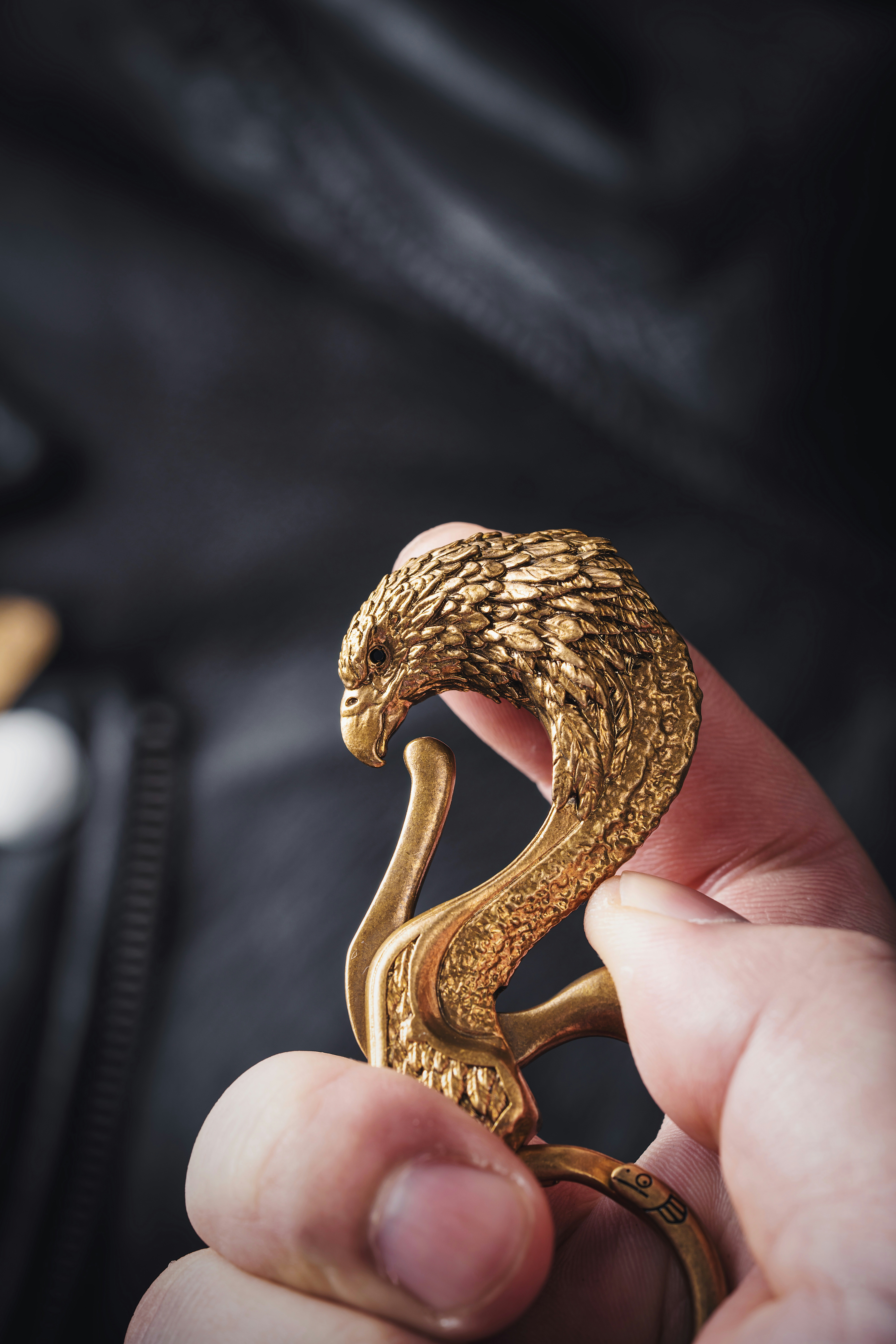 a person holding a gold snake ring in their hand