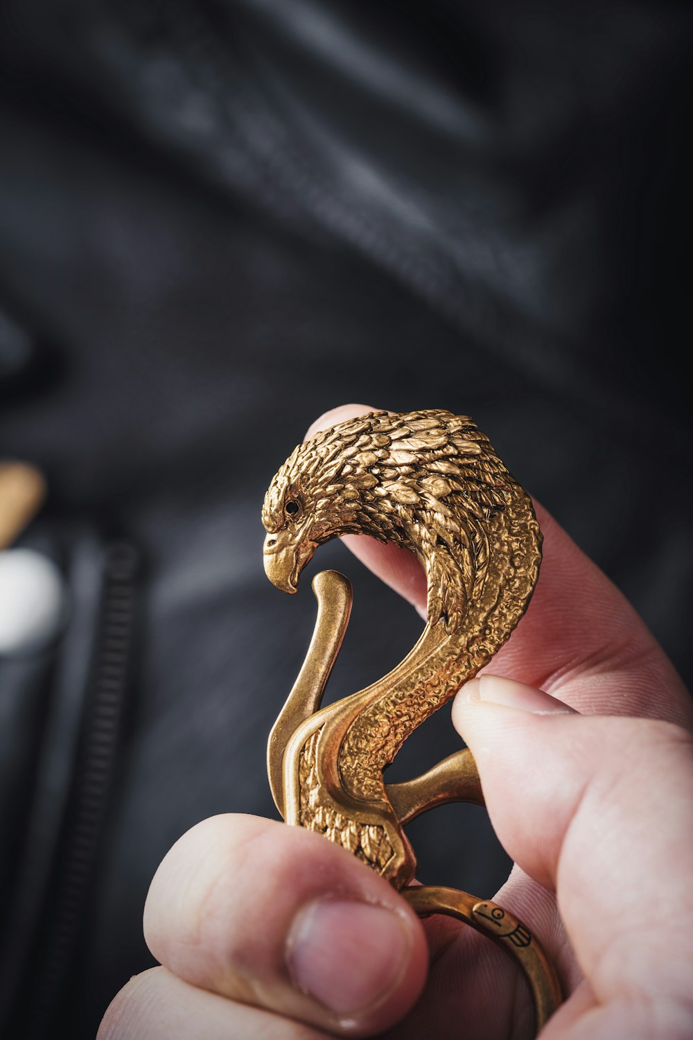 a person holding a gold snake ring in their hand