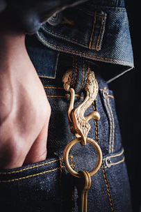 A close-up of a hand reaching into a deep pocket of a durable pair of cargo pants, highlighting the quality stitching.
