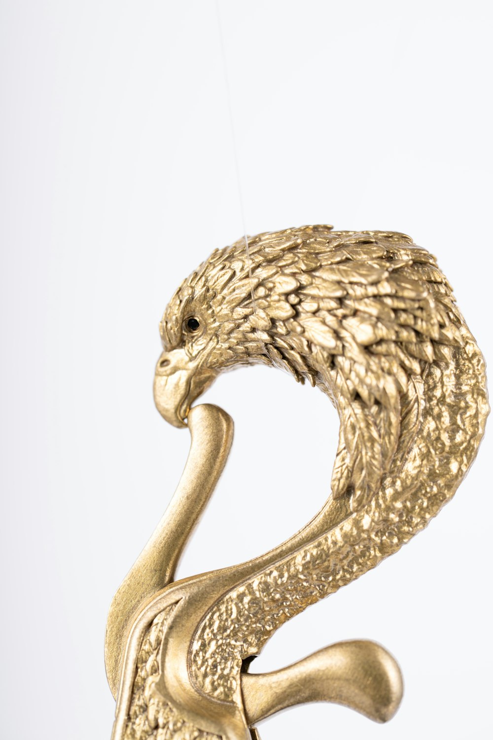 a golden snake sculpture hanging from a hook
