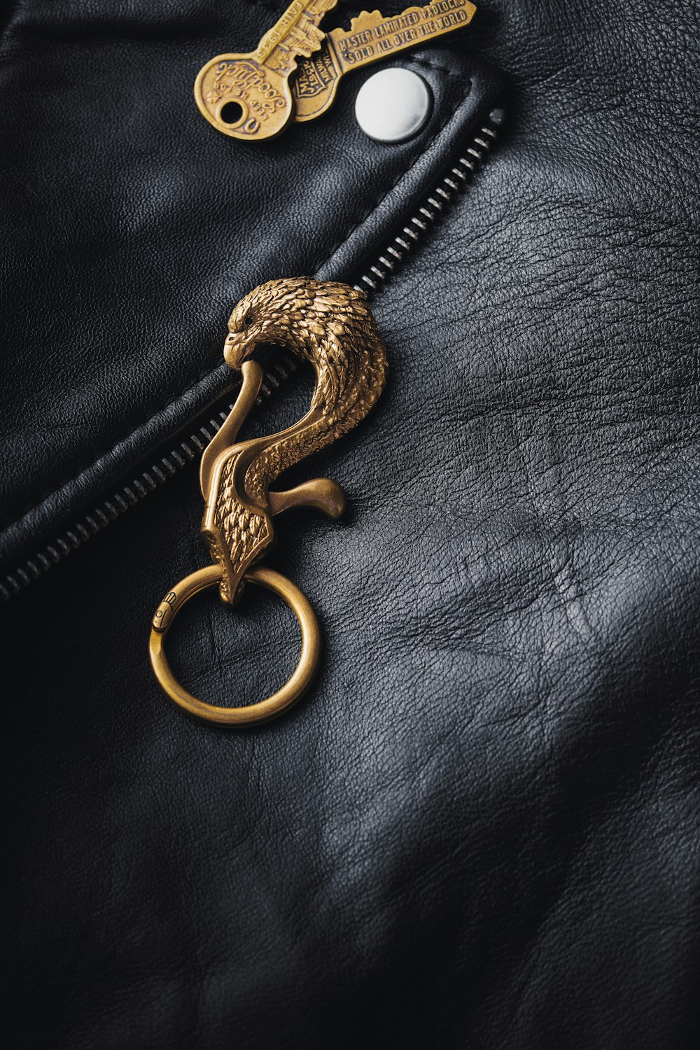 a golden key is attached to a black leather jacket