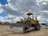 A bulldozer clearing ground at a new construction site on a cloudy day.