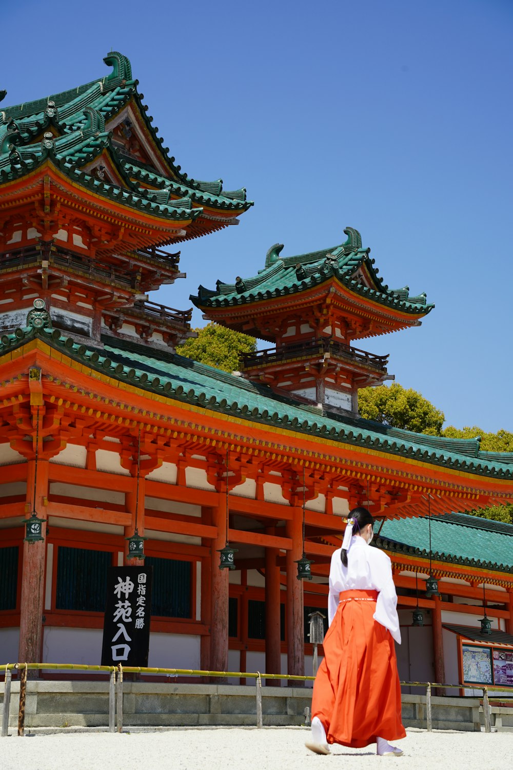 a woman in an orange dress standing in front of a building