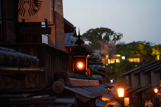 A serene evening view of Kyoto’s traditional streets glowing under warm lantern light.