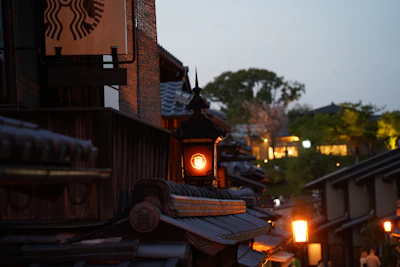 A serene evening view of Kyoto’s traditional streets glowing under warm lantern light.