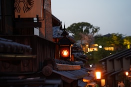 Traditional Japanese ryokan with warm orange lanterns glowing at dusk.