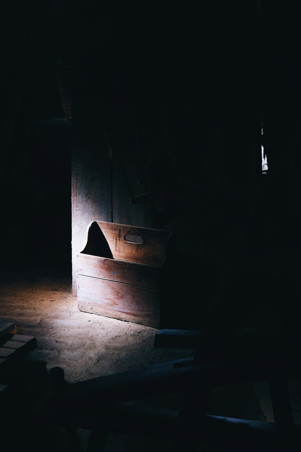 una stanza buia con una scatola di legno sul pavimento