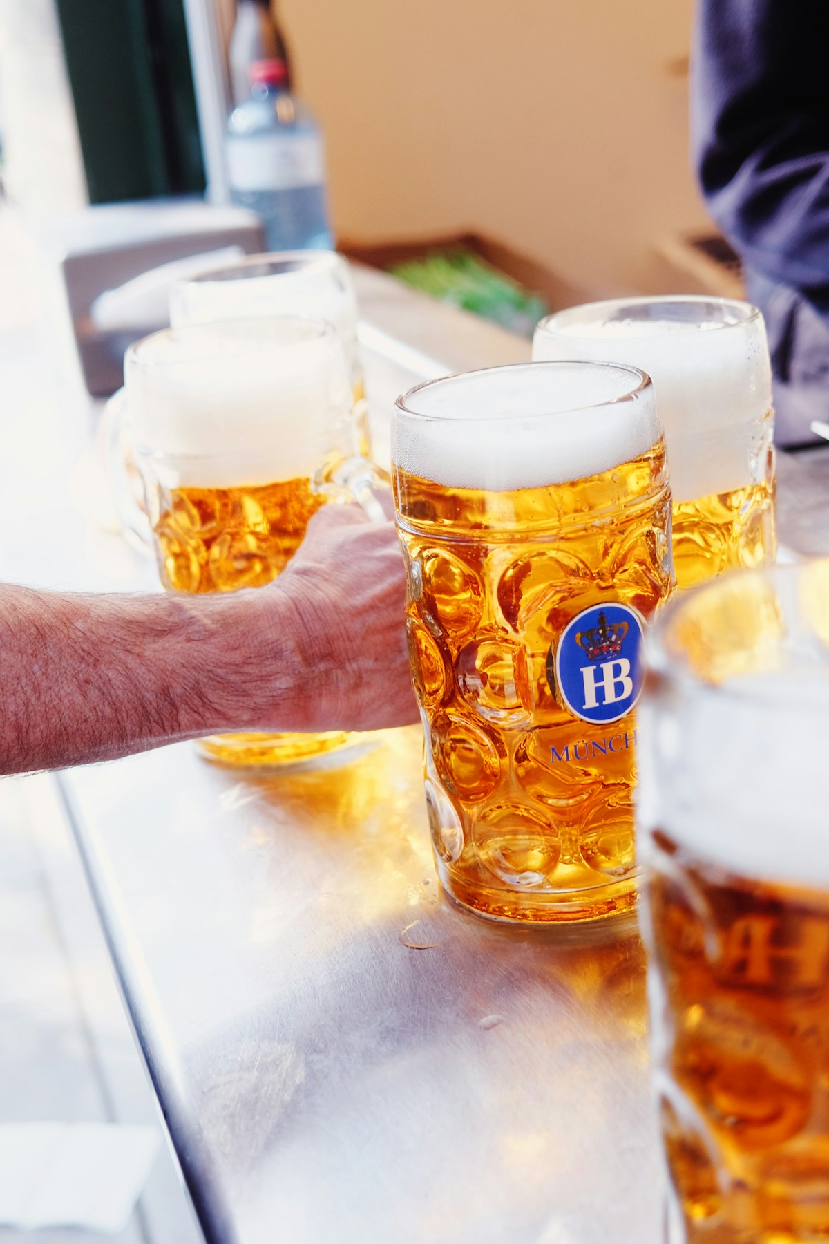 Grande tente bondée de l'Oktoberfest de Munich, tablées de fêteurs levant des chopes d'un litre