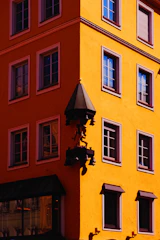 Bright yellow corner guards protecting building edges in an industrial area.