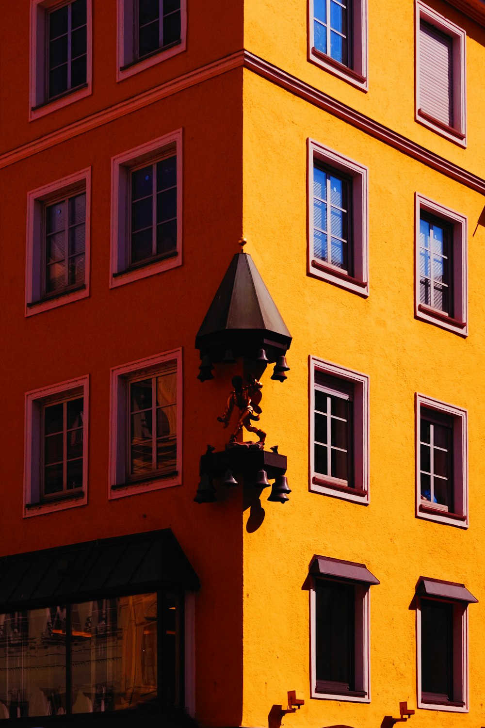 a tall yellow building with a clock on the side of it