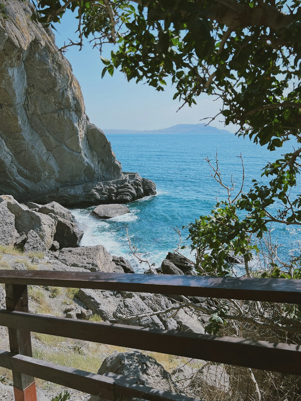 a bench sitting on the side of a cliff near the ocean