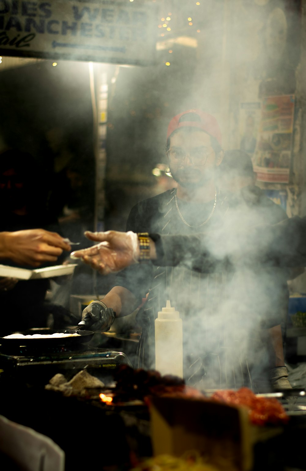 a man cooking food on a grill with smoke coming out of it