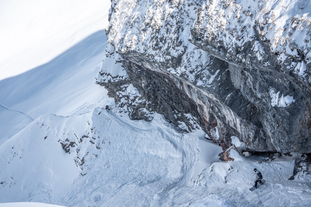 Ein Mann fährt einen verschneiten Berg hinunter