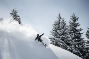 Close-up of a rider expertly carving through fresh powder with snow spraying dynamically around.