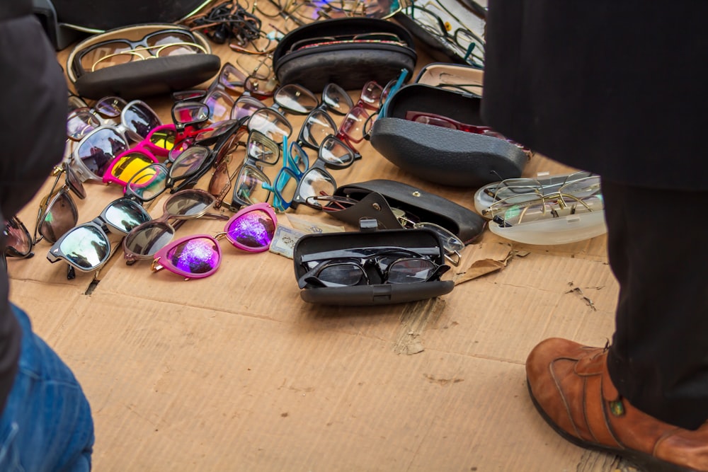 a table topped with lots of different types of sunglasses