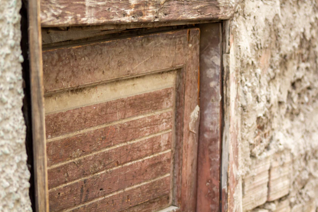 Artistic photograph of a weathered wooden door with peeling paint and rich textures.