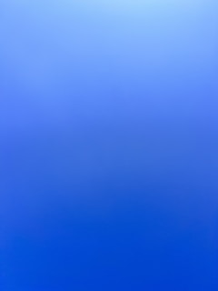 an airplane flying in the sky with a blue background