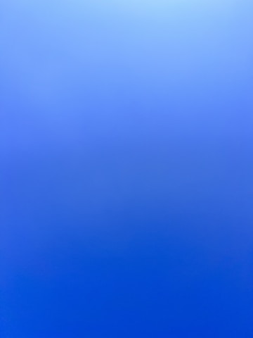 an airplane flying in the sky with a blue background