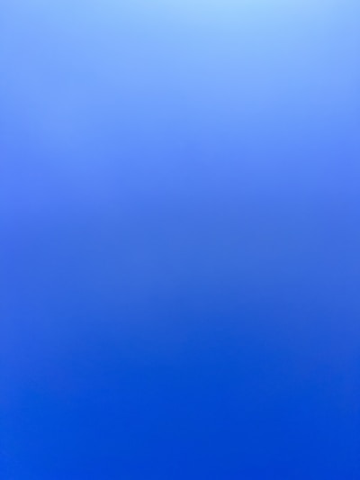 an airplane flying in the sky with a blue background