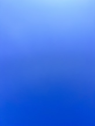an airplane flying in the sky with a blue background