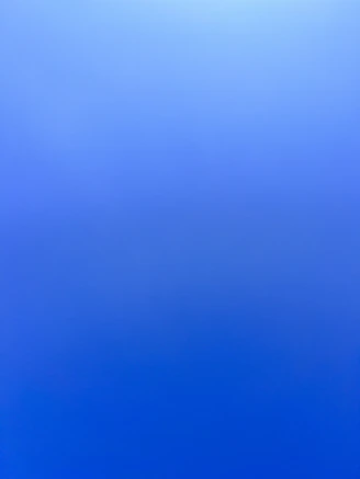 an airplane flying in the sky with a blue background