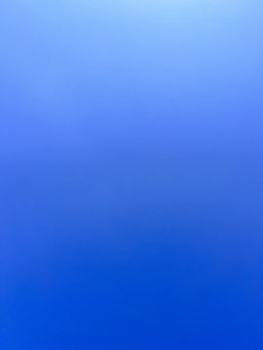 an airplane flying in the sky with a blue background