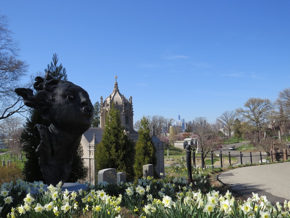 a cemetery with a statue of a dog and flowers in the foreground