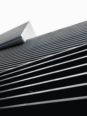 Minimalist architectural blueprint with black and white geometric lines forming a diamond shape.