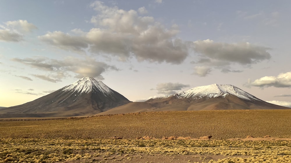 a mountain range with snow capped mountains in the distance