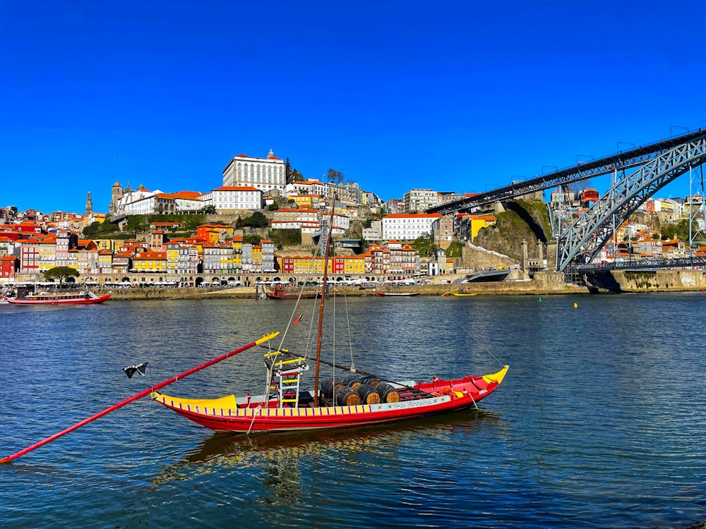 a red and yellow boat floating on top of a body of water