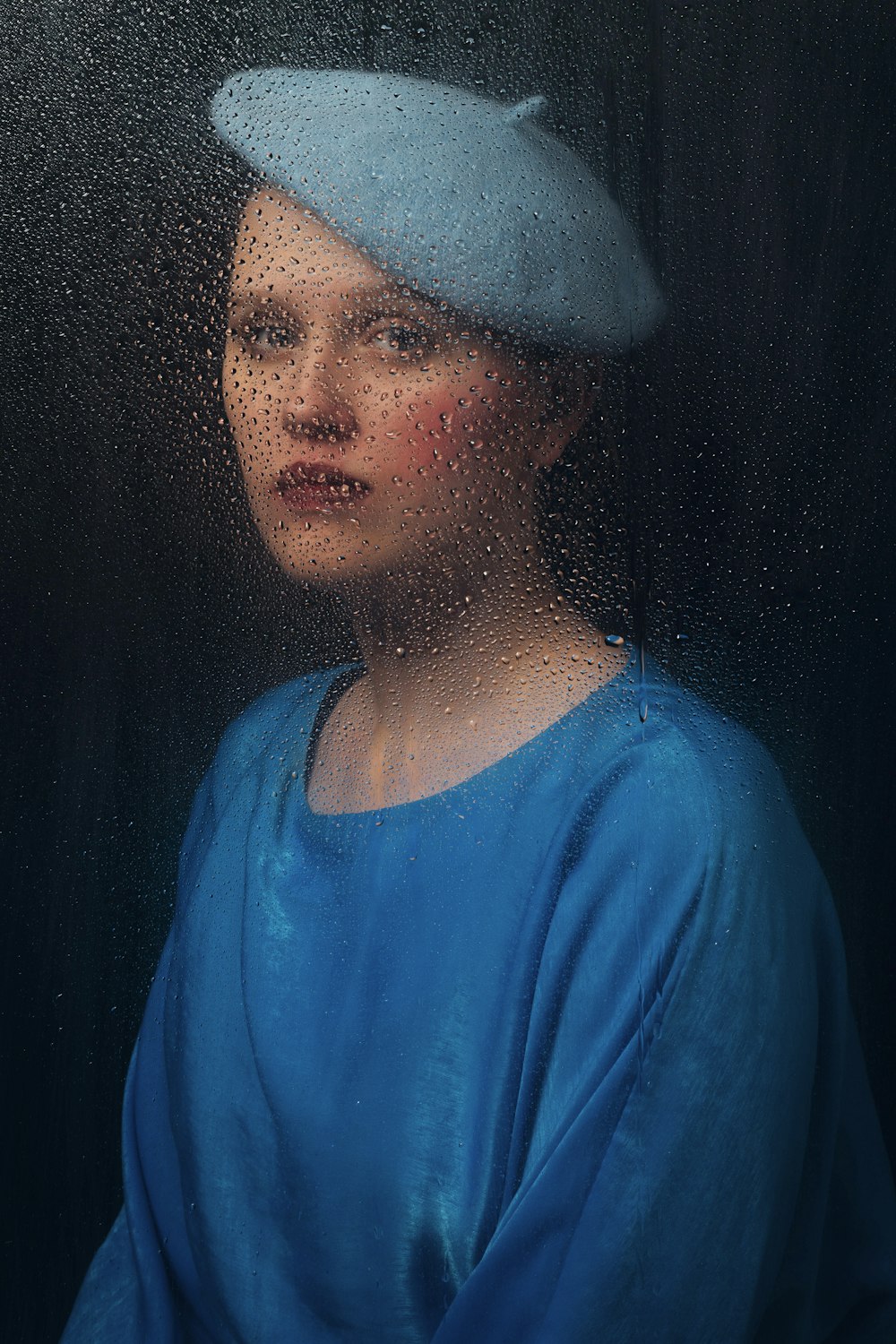 a woman wearing a blue dress and a blue hat