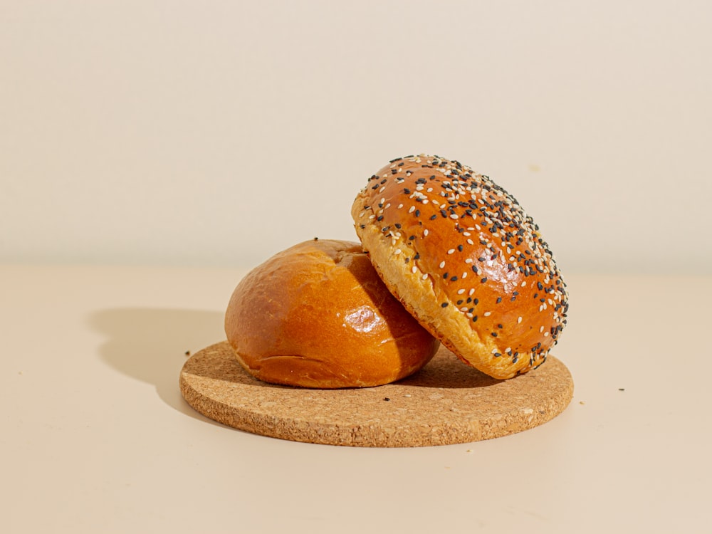 two loaves of bread sitting on top of a cork board