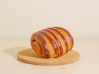 a piece of bread sitting on top of a cork coaster